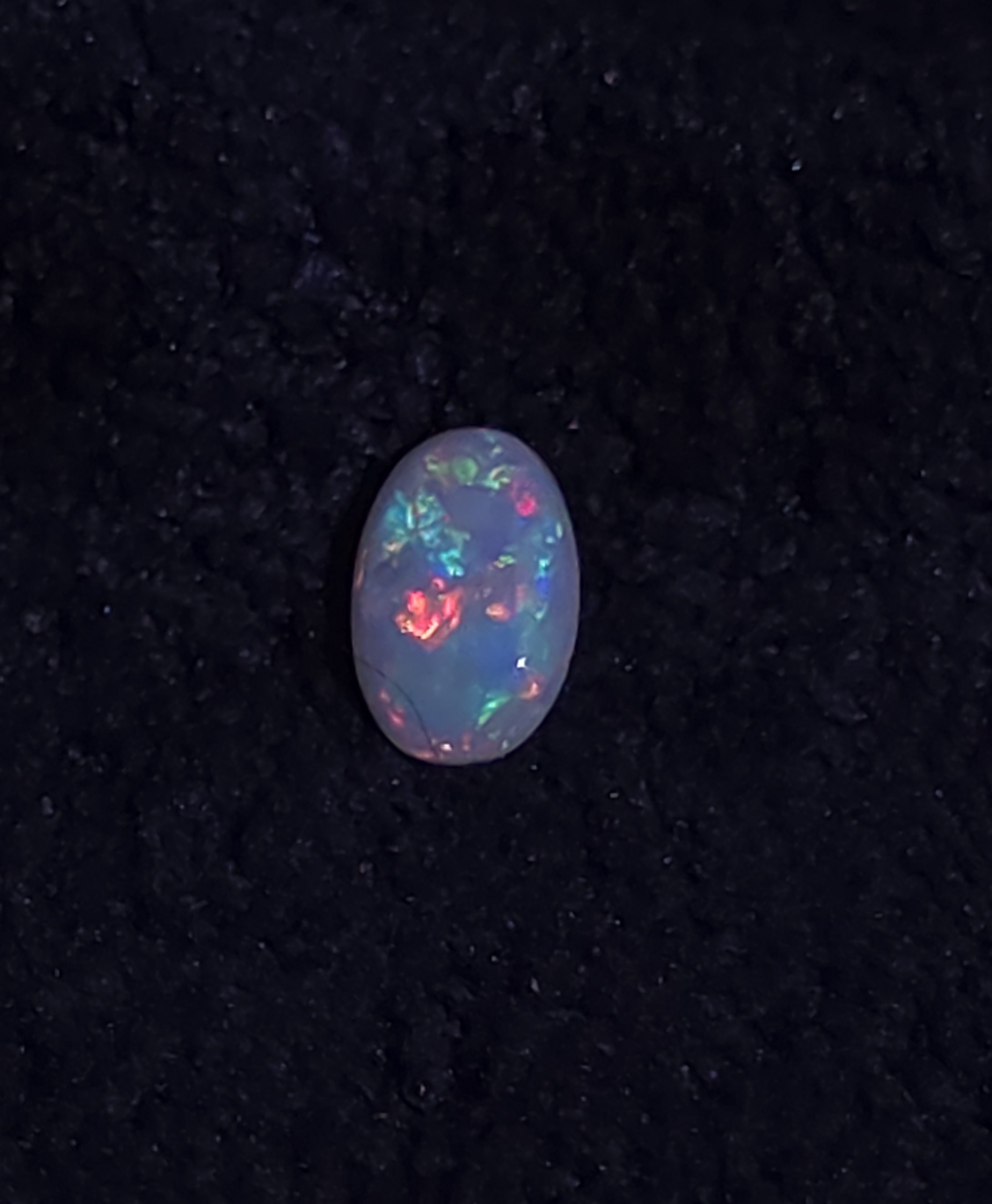 Hand-cut Australian opal with vibrant blue, green, red, and pink flashes, featured by Metrowest Opal. 